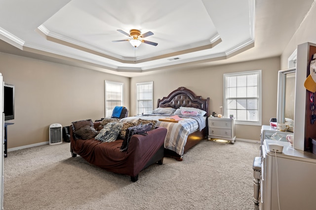 bedroom featuring light carpet, a tray ceiling, ceiling fan, and ornamental molding