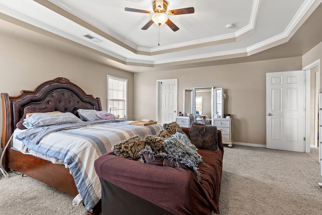 carpeted bedroom featuring ceiling fan, a raised ceiling, and ornamental molding