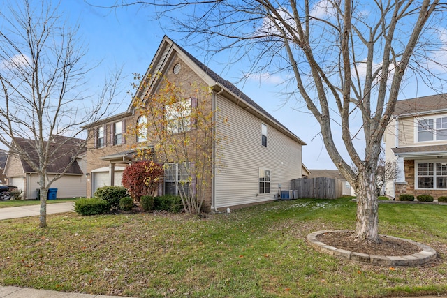 view of side of property featuring a yard, a garage, and central AC unit