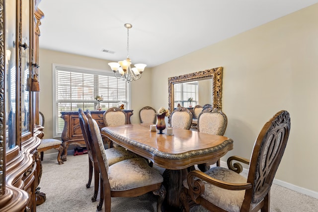 dining room featuring a notable chandelier, light carpet, and a wealth of natural light