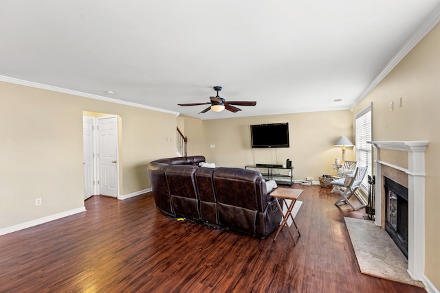 living room featuring ceiling fan, dark hardwood / wood-style flooring, a high end fireplace, and ornamental molding