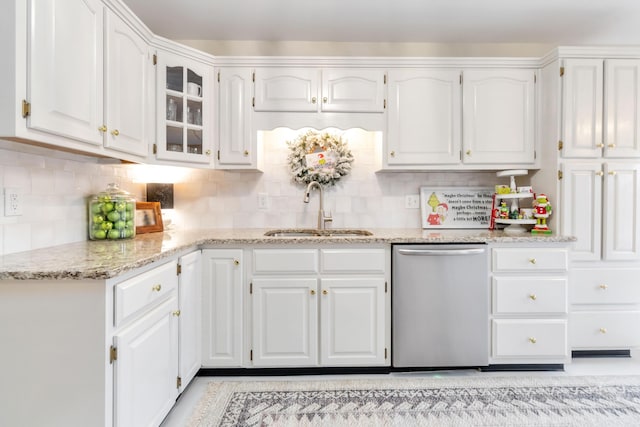 kitchen featuring stainless steel dishwasher, white cabinetry, and sink