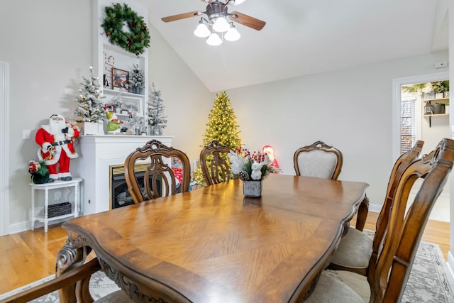 dining room featuring ceiling fan, light hardwood / wood-style floors, and lofted ceiling