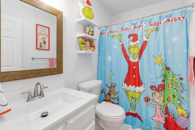 bathroom featuring curtained shower, vanity, and toilet