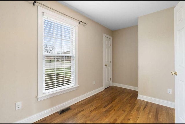 empty room featuring hardwood / wood-style flooring and a wealth of natural light