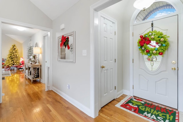 foyer entrance with vaulted ceiling and light hardwood / wood-style flooring