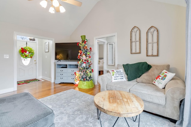 living room featuring hardwood / wood-style floors, ceiling fan, and high vaulted ceiling