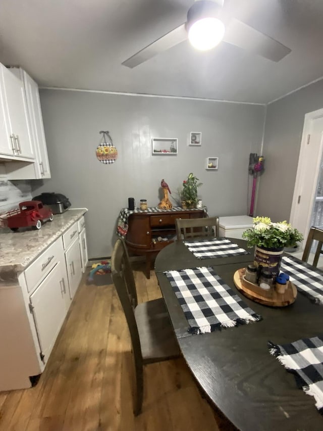 dining space with light hardwood / wood-style floors and ceiling fan