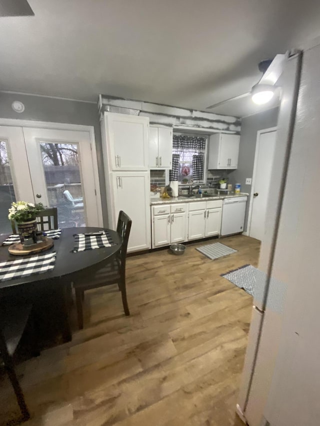 kitchen with french doors, sink, wood-type flooring, dishwasher, and white cabinetry