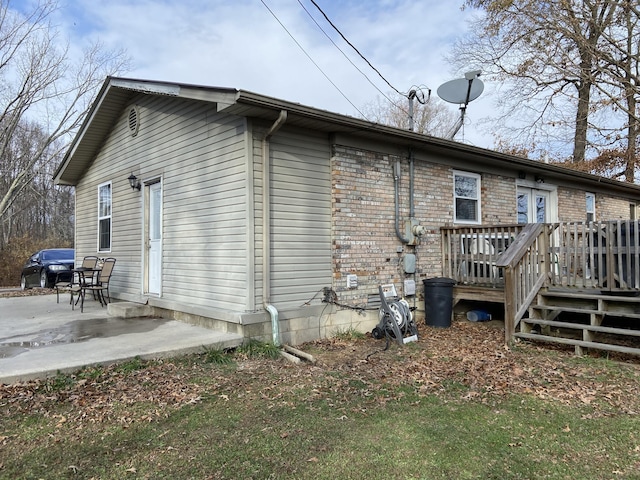 rear view of house with a patio area and a wooden deck