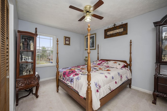 bedroom featuring carpet floors, a textured ceiling, baseboards, and a ceiling fan