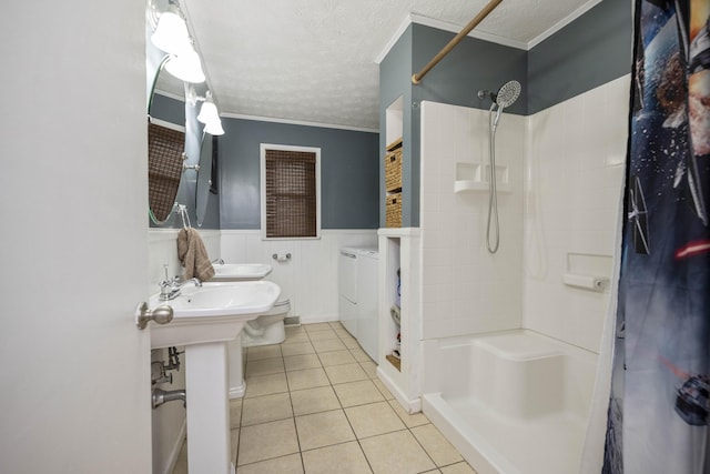 full bath featuring a wainscoted wall, tile patterned flooring, a shower, and a textured ceiling