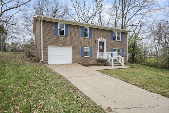 split foyer home featuring driveway, an attached garage, fence, a front lawn, and brick siding