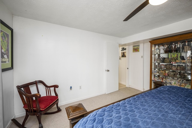 carpeted bedroom featuring a textured ceiling, ceiling fan, and baseboards