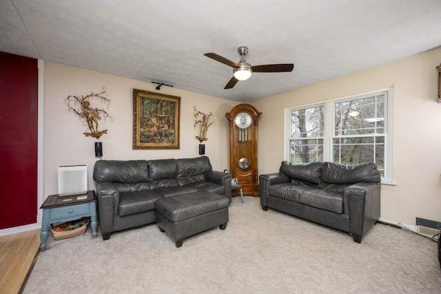 living room with carpet, ceiling fan, and a textured ceiling