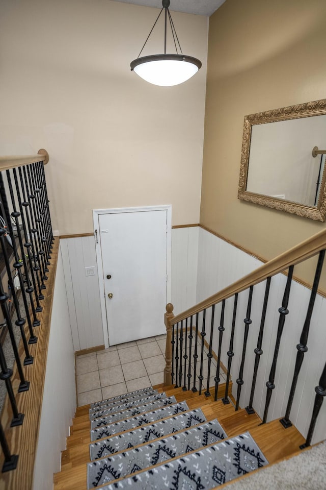 stairway featuring a wainscoted wall and wood finished floors