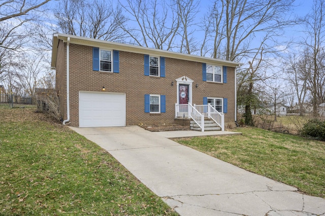 split foyer home with a garage, a front yard, concrete driveway, and brick siding