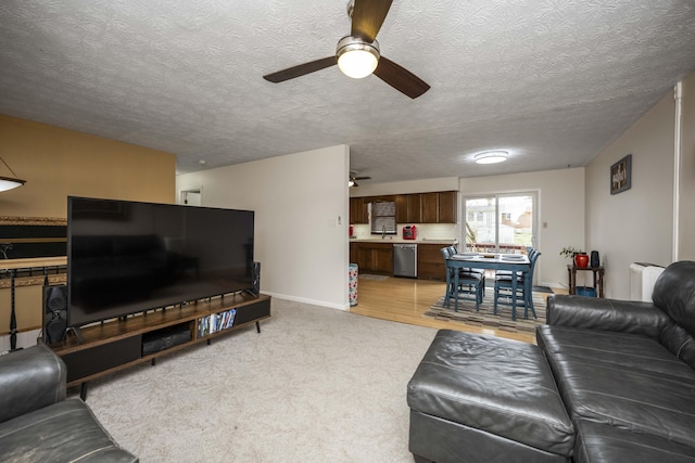 living area featuring radiator heating unit, a textured ceiling, baseboards, and a ceiling fan