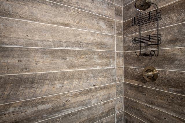 interior details with a tile shower