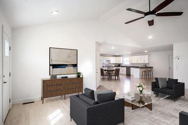 living room with high vaulted ceiling, light hardwood / wood-style flooring, ceiling fan, and a healthy amount of sunlight