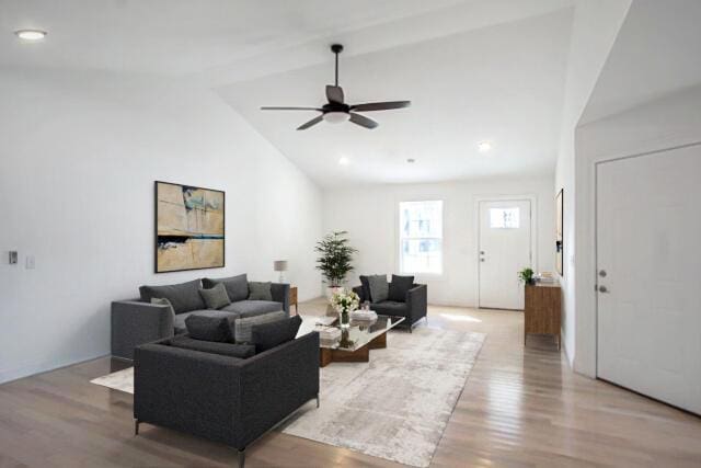 living room featuring ceiling fan, vaulted ceiling, and light wood-type flooring