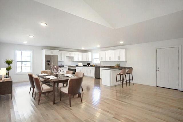 dining room with light hardwood / wood-style floors and lofted ceiling