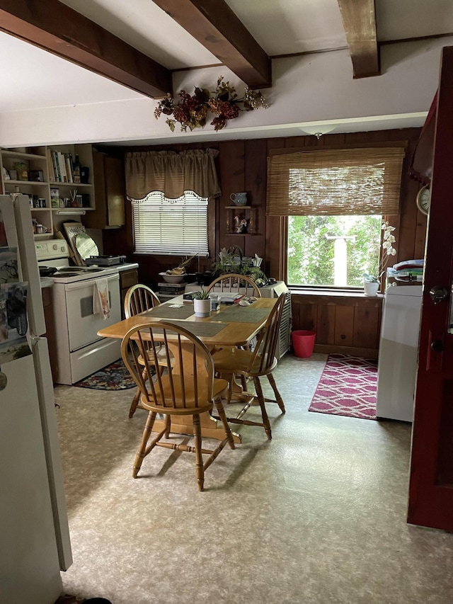 carpeted dining space with beam ceiling and plenty of natural light