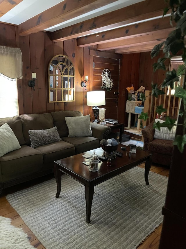 living room featuring beam ceiling, wood walls, and hardwood / wood-style flooring