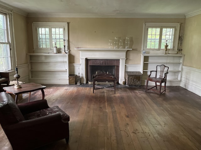 sitting room featuring a fireplace, crown molding, dark hardwood / wood-style flooring, and plenty of natural light