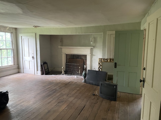 living room with wood-type flooring and a brick fireplace