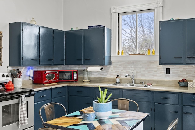 kitchen featuring decorative backsplash, sink, stainless steel range with electric cooktop, and blue cabinets