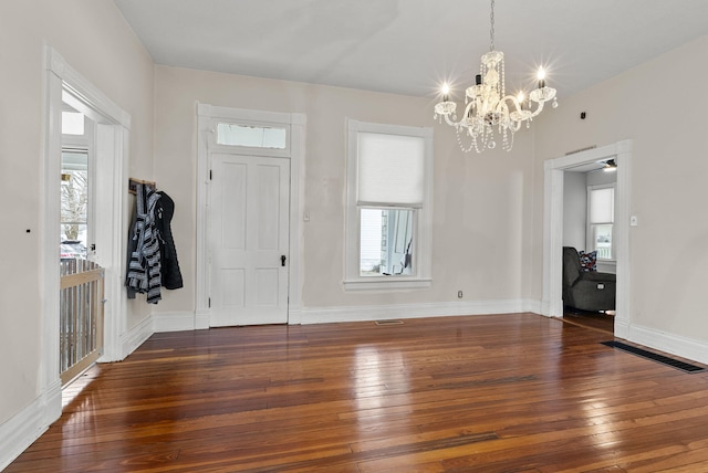 entryway featuring plenty of natural light, dark wood-type flooring, and a chandelier