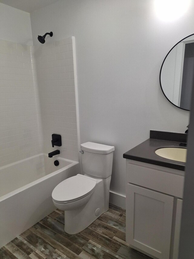 full bathroom with hardwood / wood-style floors, vanity, toilet, and shower / bath combination