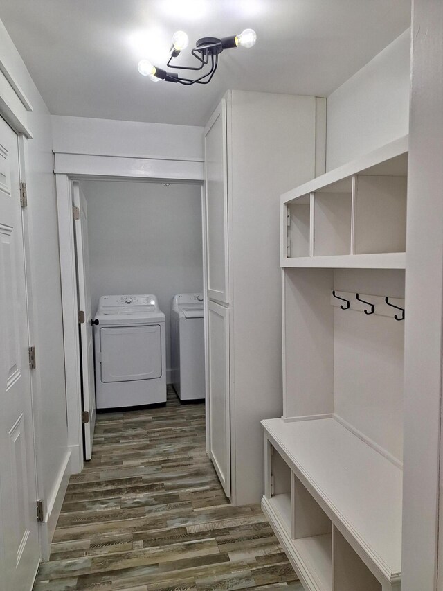 mudroom with dark hardwood / wood-style flooring, an inviting chandelier, and washing machine and clothes dryer