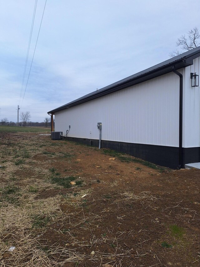 view of front of home with covered porch, a garage, and central AC