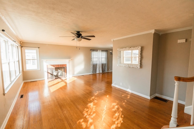 unfurnished living room with wood-type flooring, a textured ceiling, ceiling fan, and crown molding