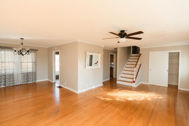 unfurnished living room featuring hardwood / wood-style floors, ceiling fan with notable chandelier, and ornamental molding