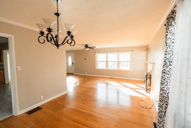 unfurnished living room with ceiling fan with notable chandelier, light hardwood / wood-style floors, and ornamental molding