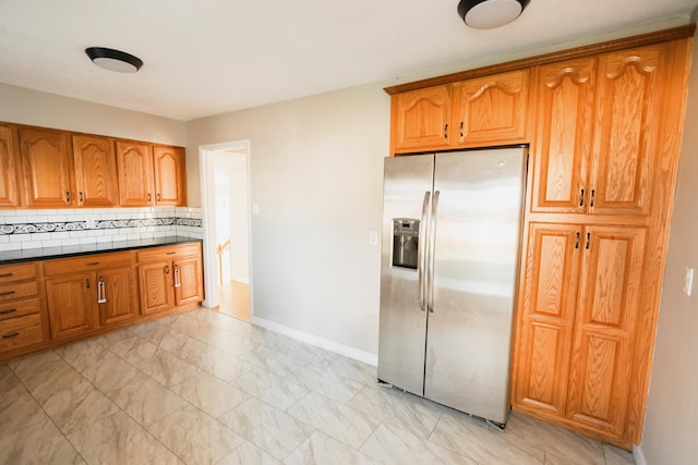 kitchen with decorative backsplash and stainless steel fridge