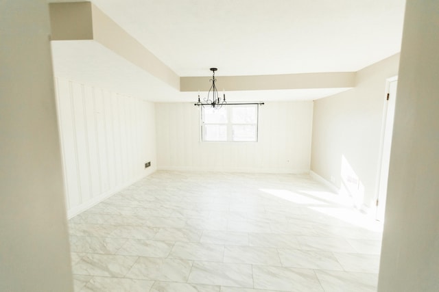 spare room featuring an inviting chandelier