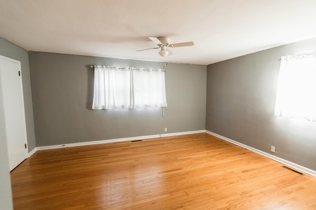 empty room with hardwood / wood-style floors and ceiling fan