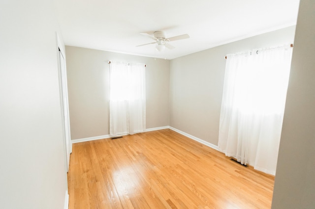 unfurnished room with light hardwood / wood-style floors, ceiling fan, and a healthy amount of sunlight