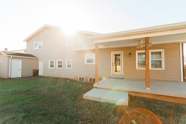 rear view of property with a patio area, a yard, and a storage unit