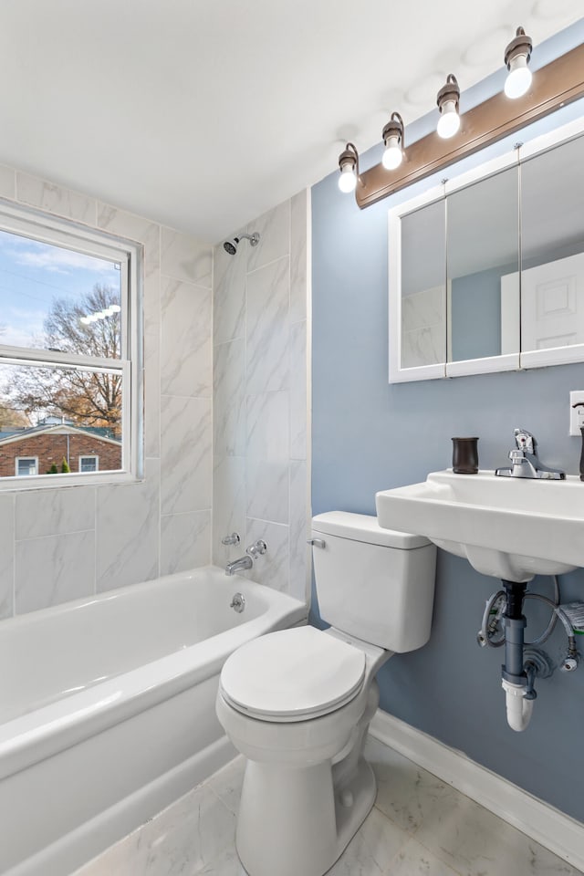 bathroom with tiled shower / bath combo and toilet