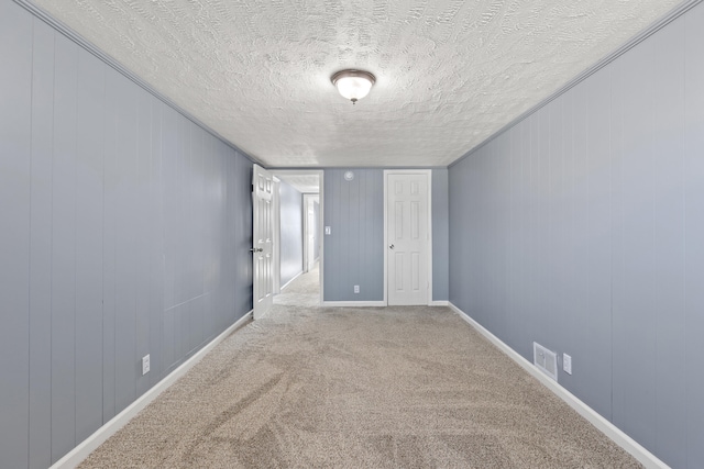 carpeted spare room featuring a textured ceiling