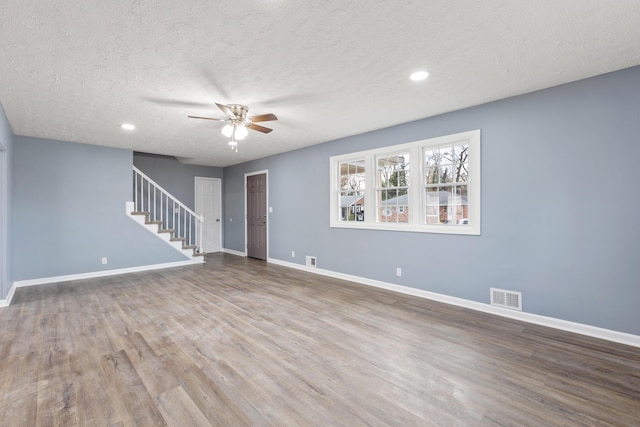 spare room with a textured ceiling, hardwood / wood-style flooring, and ceiling fan