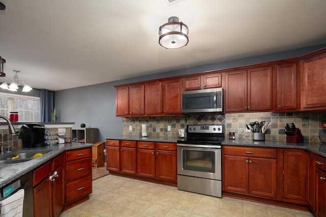 kitchen featuring tasteful backsplash, stainless steel appliances, sink, decorative light fixtures, and dark stone countertops