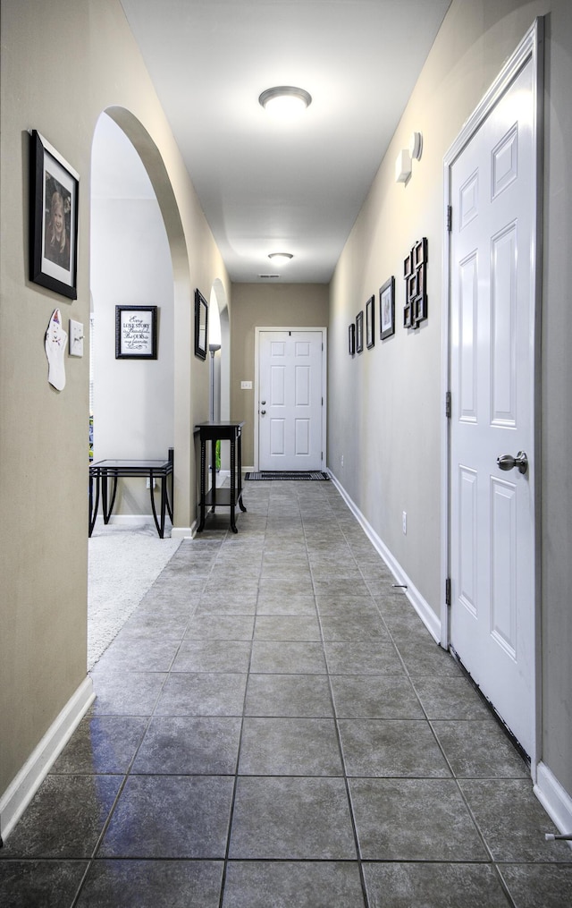 hallway with dark tile patterned floors