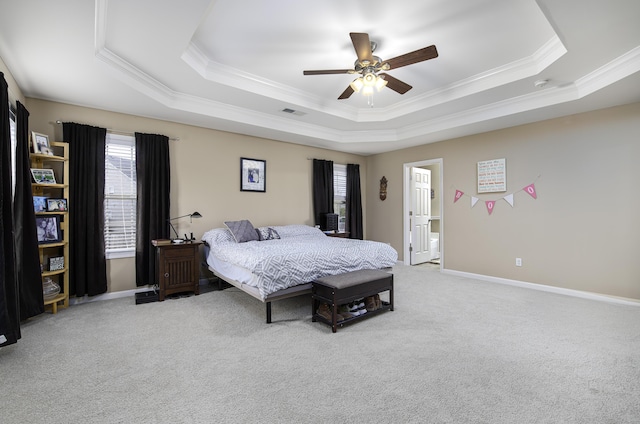 carpeted bedroom with ceiling fan, ornamental molding, and a tray ceiling