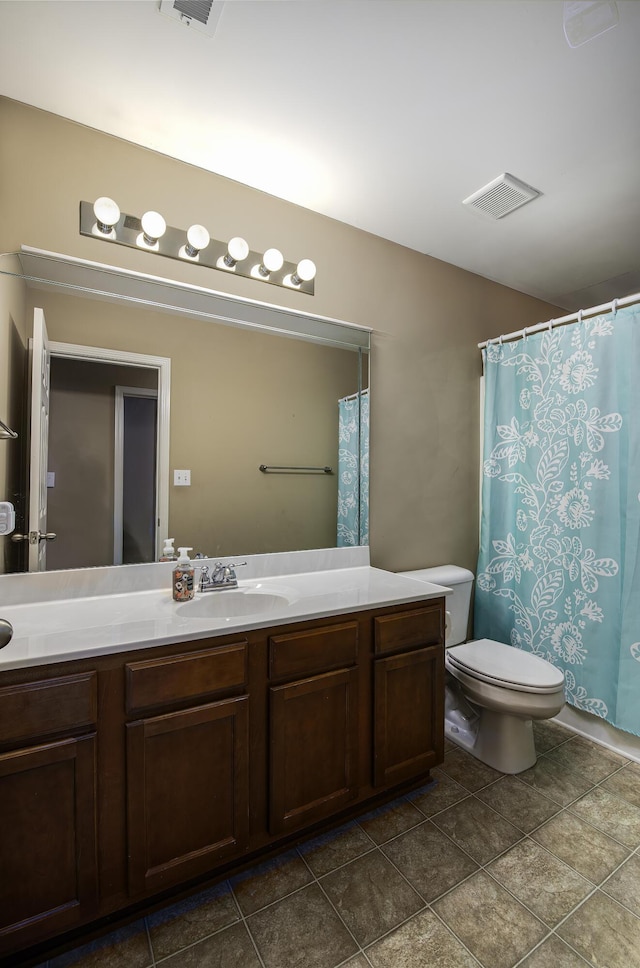 bathroom featuring tile patterned floors, vanity, and toilet